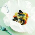 Fisch mit Muscheln in der Papierhülle gegart
